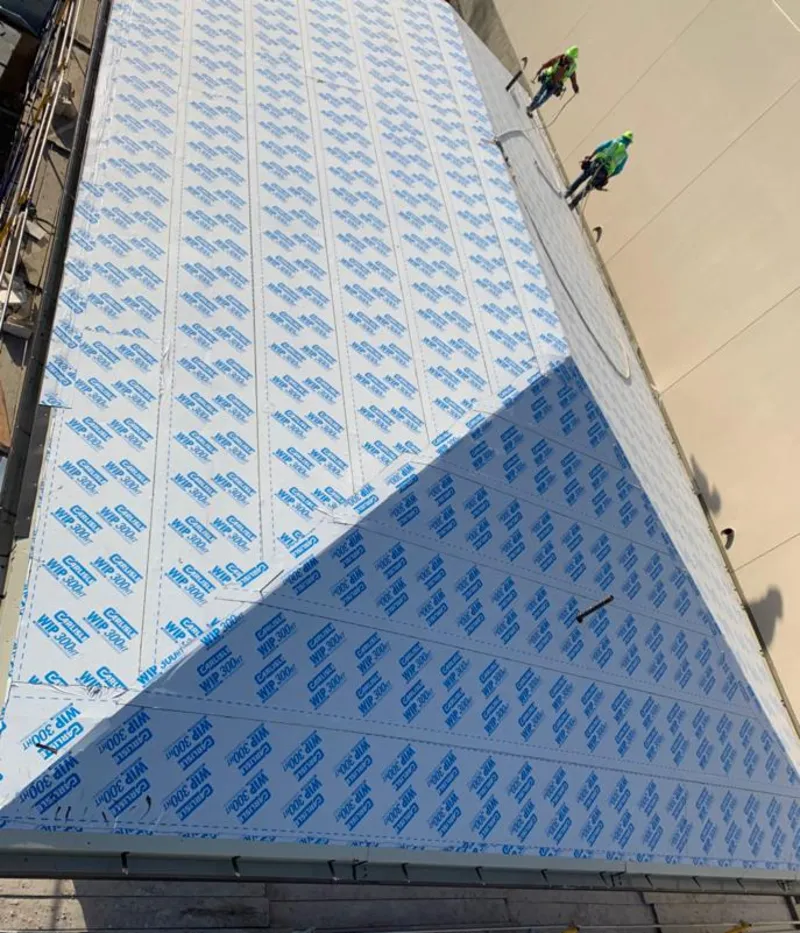 Professional roofers installing underlayment on a metal roof in Goodyear